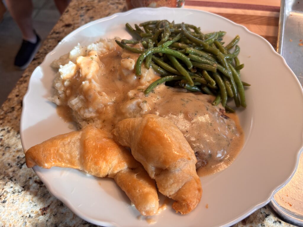 Homestyle Salisbury Steak over mashed potatoes and green beans and crescent rolls