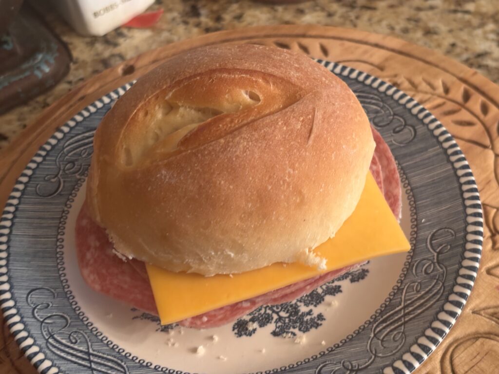 A sandwich on a blue country plate using the homemade Italian semolina rolls